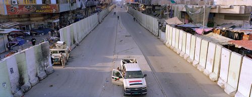 Багдад, Ирак. Снимката показва града, разделен от стена и военен автомобил.