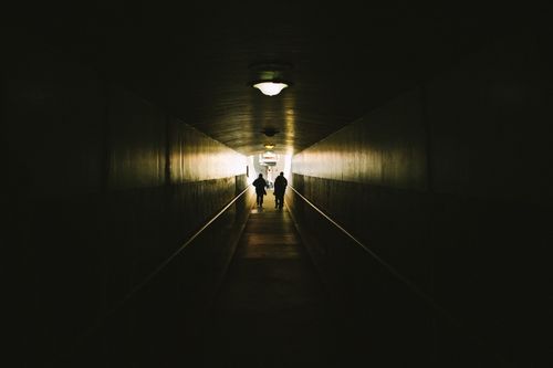 Тунел, в чийто край се вижда светлина и силуети на двама души